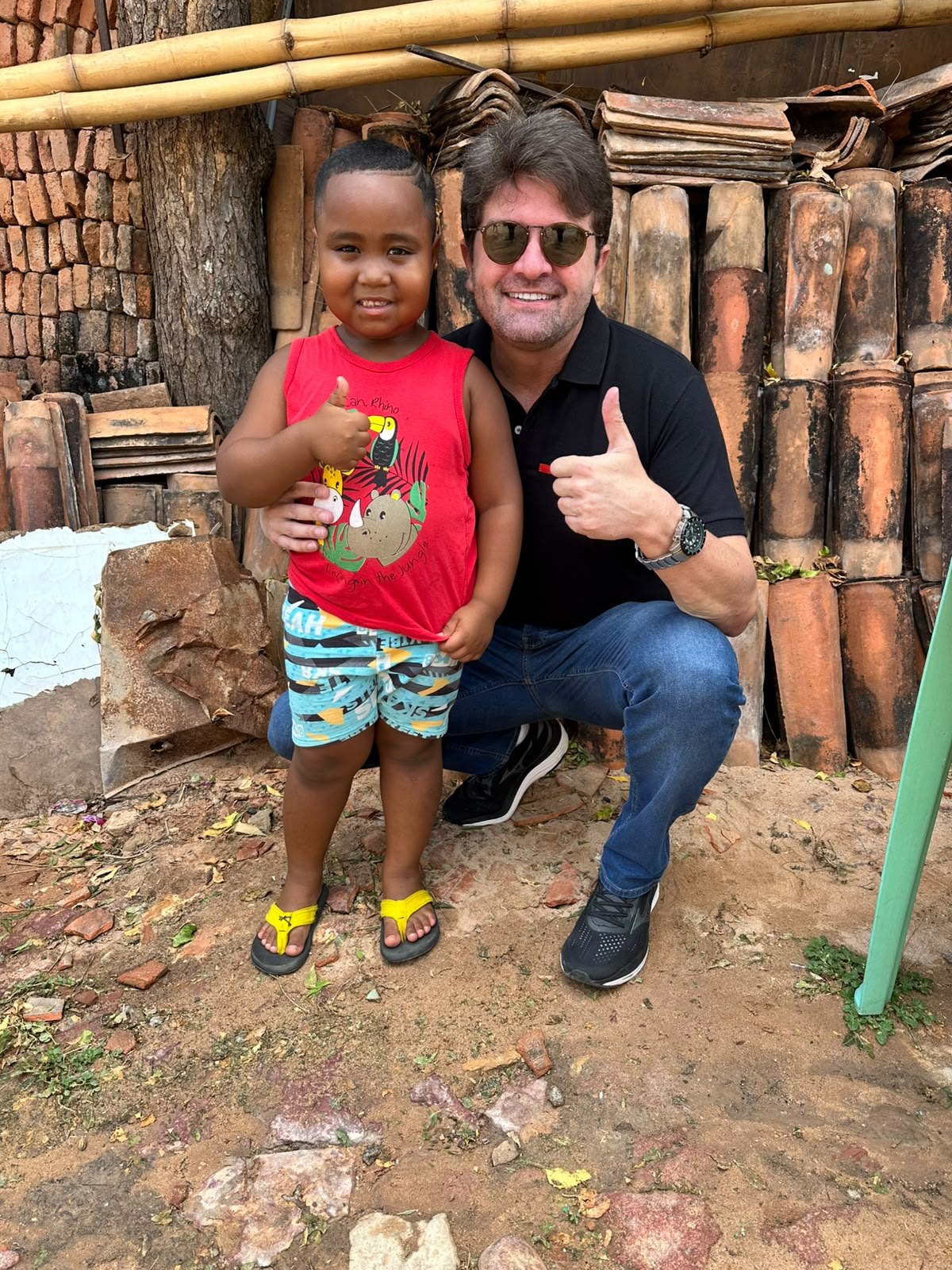 Dr. Aloísio com criança em visita comunitária